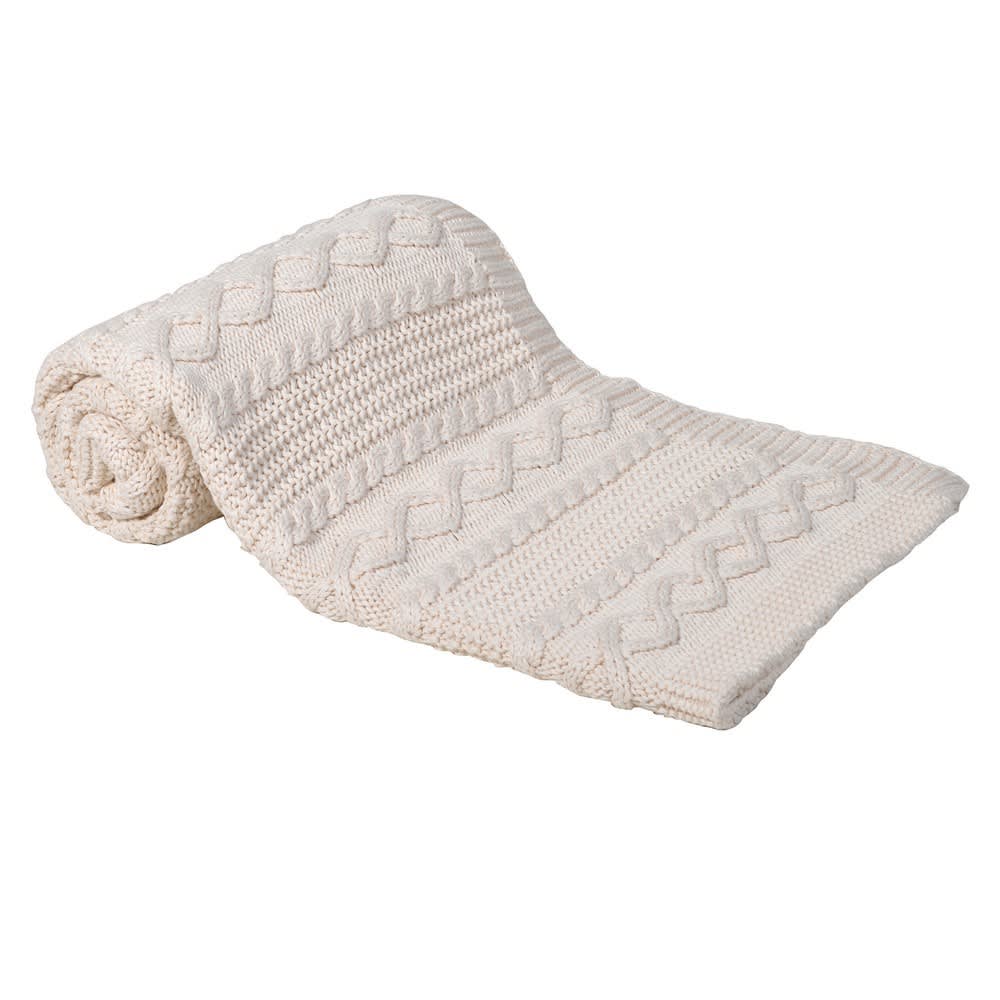 Chunk knitted cream throw half rolled up on a white background.