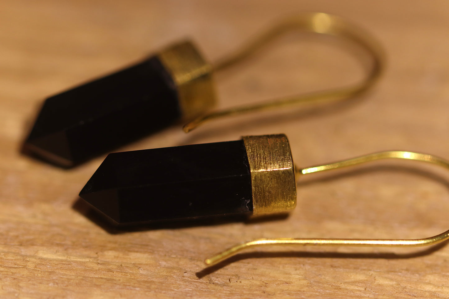 Gold plated earrings with a black crystal point. 